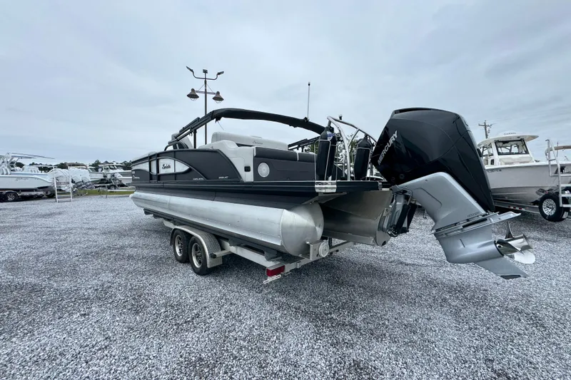 Slide: The Image of 2023 Barletta CORSA 25UC pontoon boat on trailer, featuring a powerful Mercury outboard engine. - 14