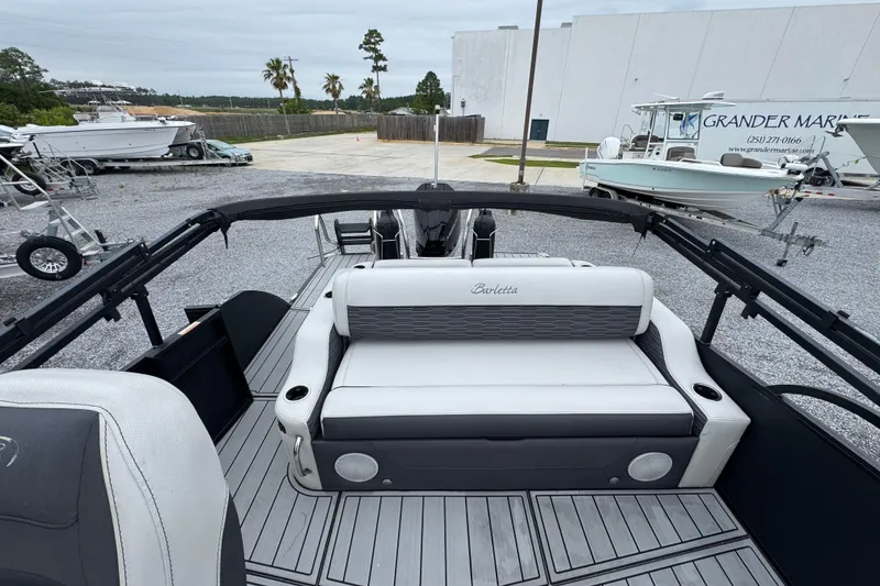 Slide: The Image of 2023 Barletta CORSA 25UC pontoon boat with sleek seating and modern design at a marina. - 27