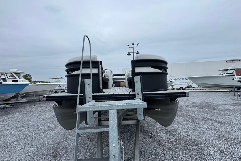 Slide: The Image of 2023 Barletta CORSA 25UC pontoon boat on display in a gravel lot. - 5