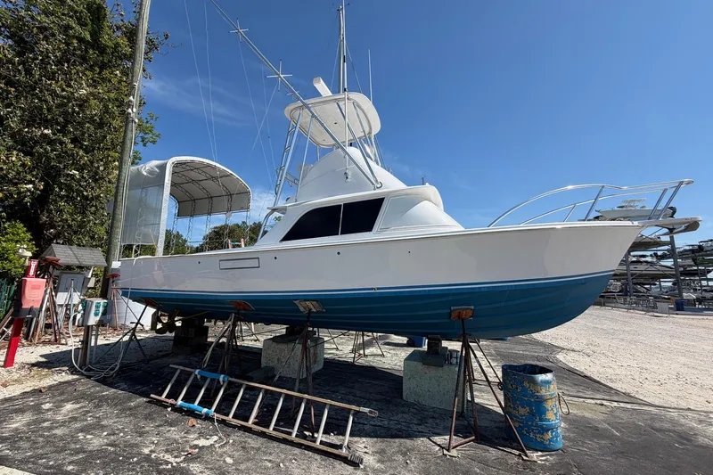 The Image of 1977 Bertram 31 Flybridge Cruiser on dry dock, showcasing classic design and structure. - 1
