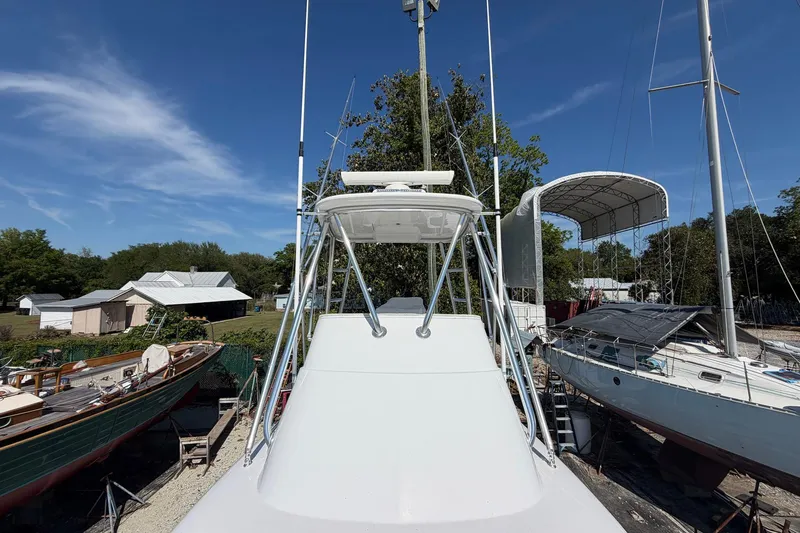 Slide: The Image of 1977 Bertram 31 Flybridge Cruiser in a boatyard under clear blue skies. - 11