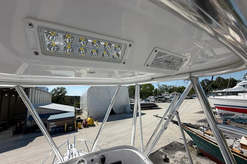 Slide: The Image of 1977 Bertram 31 Flybridge Cruiser with LED lights, docked in a marina. - 22
