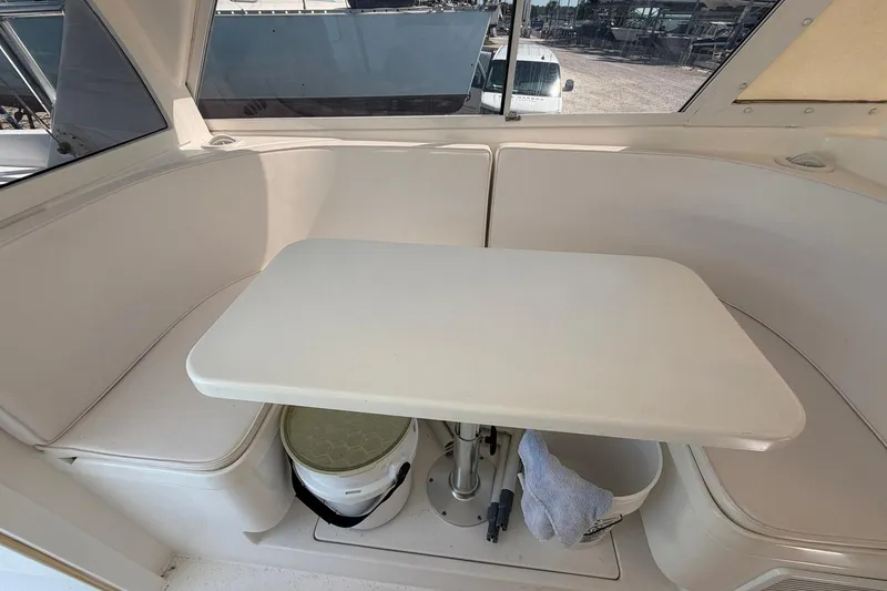 Slide: The Image of Interior of 1977 Bertram 31 Flybridge Cruiser with white seating and table. - 30