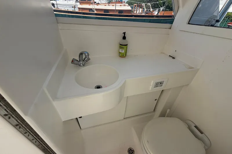 Slide: The Image of 1977 Bertram 31 Flybridge Cruiser bathroom with sink, faucet, and toilet. - 32