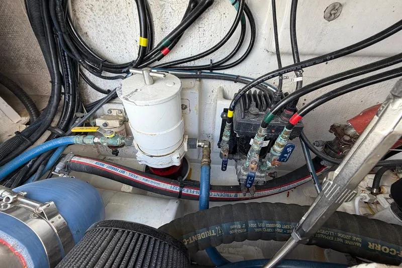 Slide: The Image of Engine compartment of a 1977 Bertram 31 Flybridge Cruiser with visible hoses and wiring. - 43