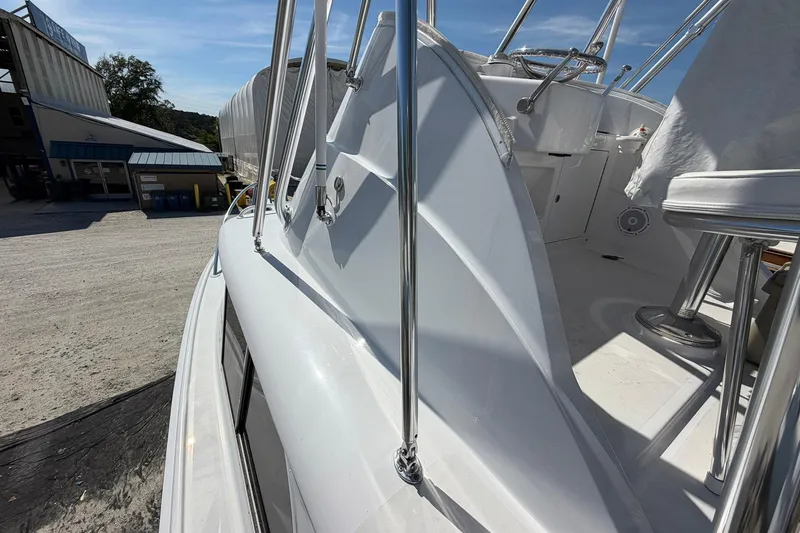 Slide: The Image of 1977 Bertram 31 Flybridge Cruiser, showcasing sleek design and polished metalwork in a marina setting. - 9
