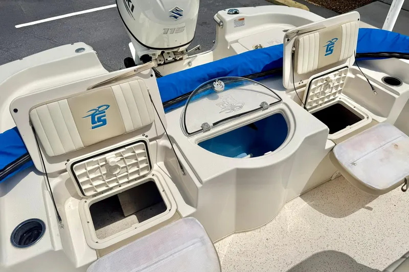 Slide: The Image of 2019 Carolina Skiff 198 DLV boat interior with storage compartments and Suzuki 115 engine. - 26