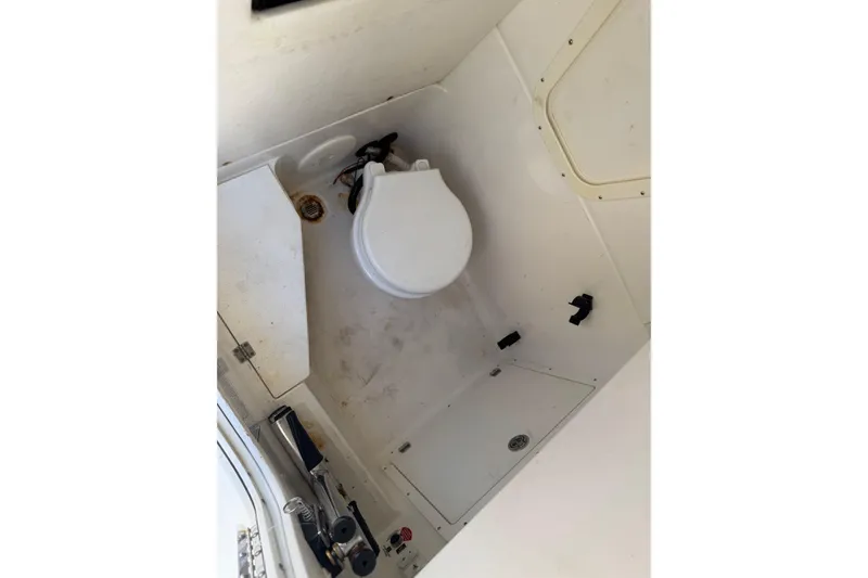 Slide: The Image of Interior of 2022 Century 2600 Center Console boat featuring a compact marine toilet. - 12