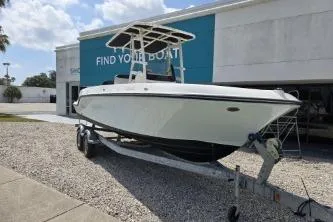 Slide: The Image of 2023 Trophy T22 boat on trailer outside dealership under blue sky. - 4