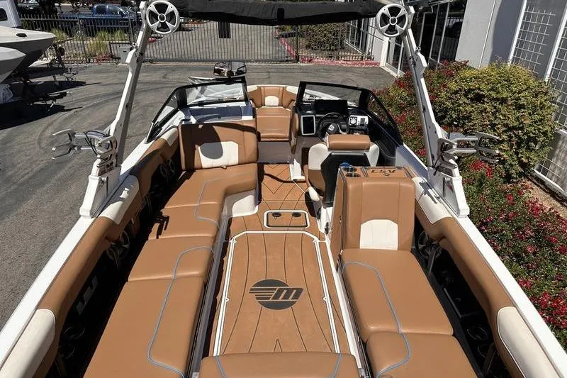 Slide: The Image of 2019 Malibu Wakesetter 25 LSV boat interior with tan seating and modern dashboard. - 3