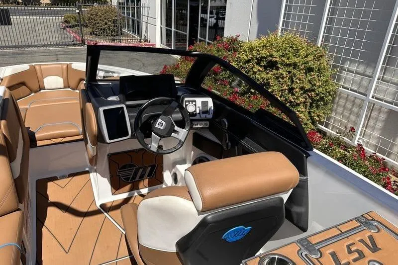 Slide: The Image of 2019 Malibu Wakesetter 25 LSV boat interior with tan seating and modern dashboard. - 6
