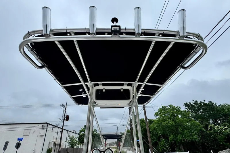 Slide: The Image of T-top of 2021 NauticStar 227 XTS boat with rod holders against cloudy sky. - 11