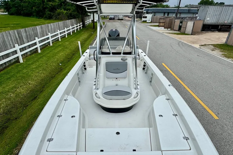 Slide: The Image of 2021 NauticStar 227 XTS boat on a road, showcasing spacious deck and seating. - 15