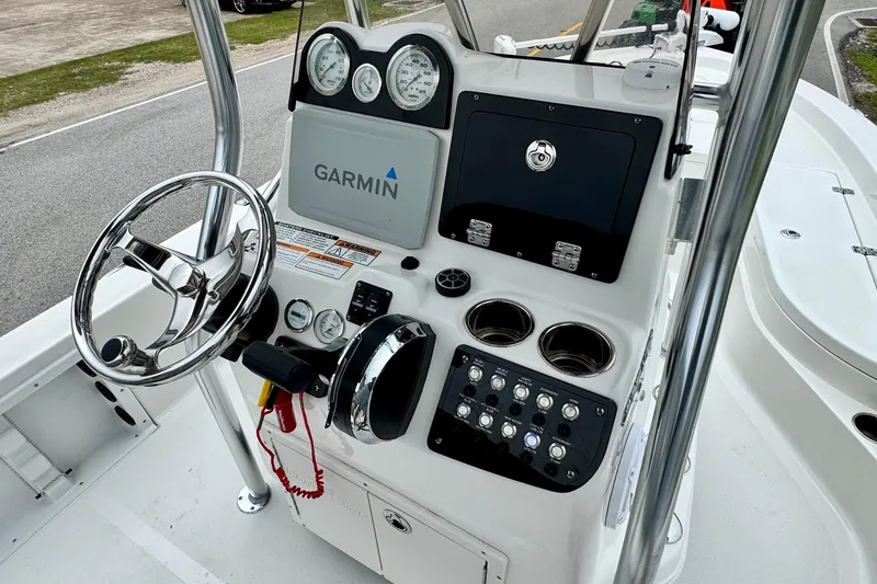 Slide: The Image of 2021 NauticStar 227 XTS boat console with Garmin navigation and chrome steering wheel. - 16