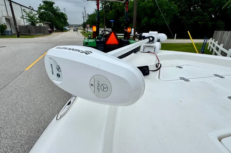 Slide: The Image of 2021 NauticStar 227 XTS boat with Minn Kota Riptide trolling motor on a street. - 17