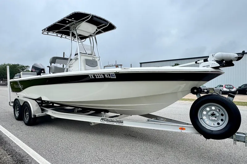 Slide: The Image of 2021 NauticStar 227 XTS boat on trailer, parked outdoors, overcast sky. - 5