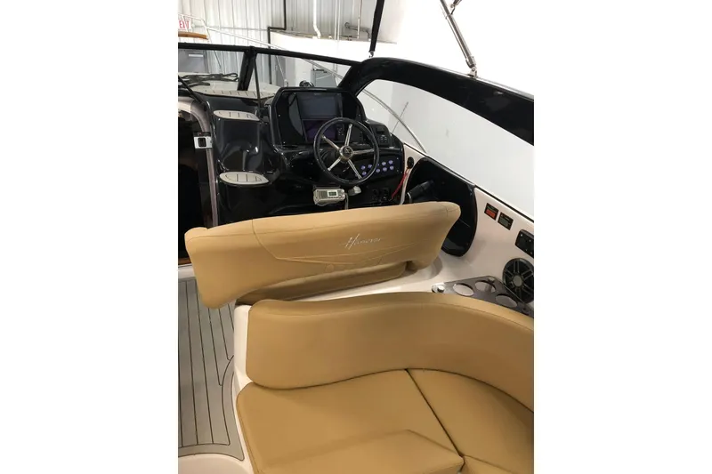 Slide: The Image of 2024 Hanover 305 boat interior with tan seating and modern dashboard controls. - 11