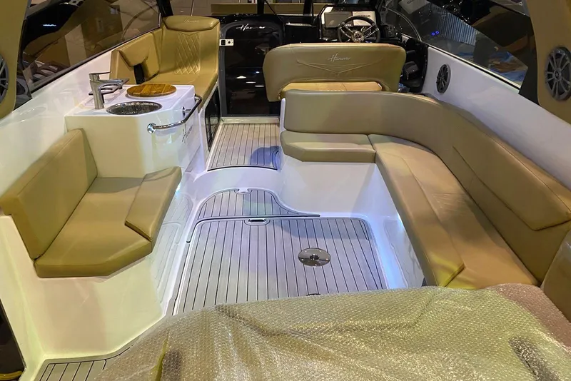Slide: The Image of 2024 Hanover 305 boat interior with beige seating and modern amenities. - 19