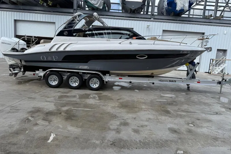 Slide: The Image of 2024 Hanover 305 boat on trailer, parked in industrial area. - 2