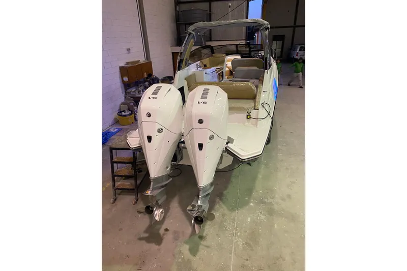 Slide: The Image of 2024 Hanover 305 boat with dual outboard engines in a garage setting. - 9