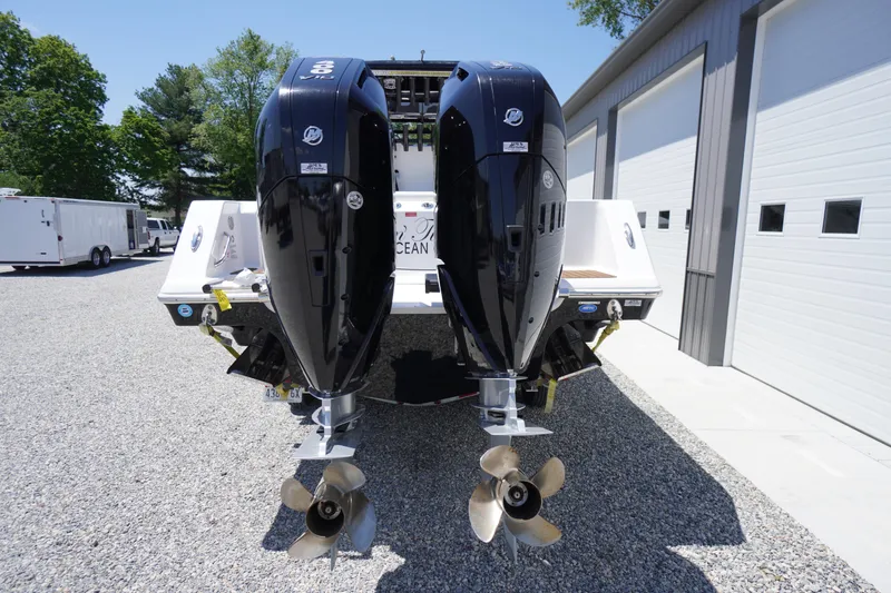 Slide: The Image of 2024 Tidewater 320 CC Adventure boat with dual outboard engines, parked on gravel. - 10