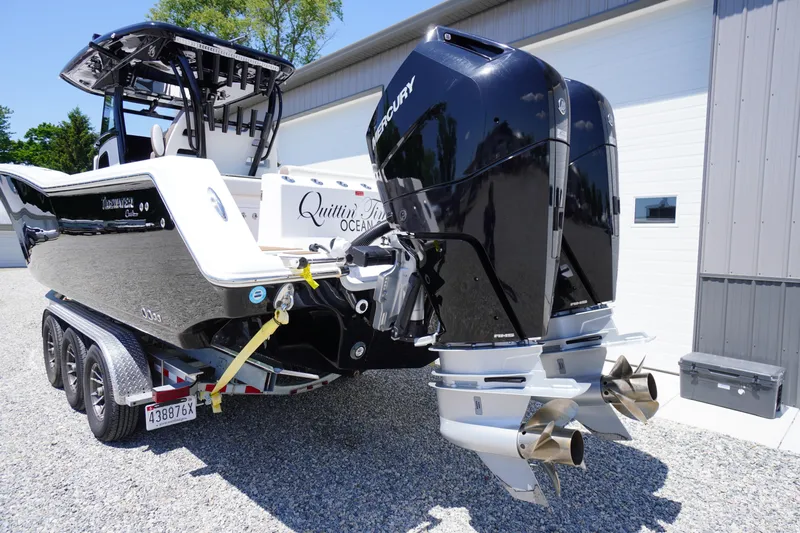 Slide: The Image of 2024 Tidewater 320 CC Adventure boat with dual Mercury engines on a trailer. - 11