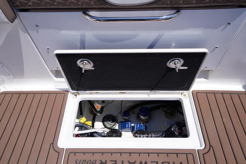 Slide: The Image of 2024 Tidewater 320 CC Adventure boat storage compartment with open hatch and visible equipment. - 18