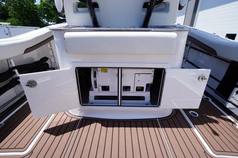 Slide: The Image of 2024 Tidewater 320 CC Adventure boat storage compartment with open doors on deck. - 21
