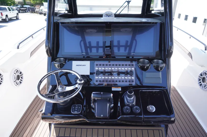 Slide: The Image of 2024 Tidewater 320 CC Adventure boat dashboard with steering wheel and control panel. - 26