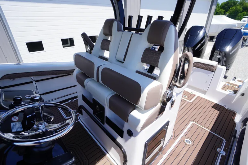 Slide: The Image of 2024 Tidewater 320 CC Adventure boat interior with dual seats and steering wheel. - 37