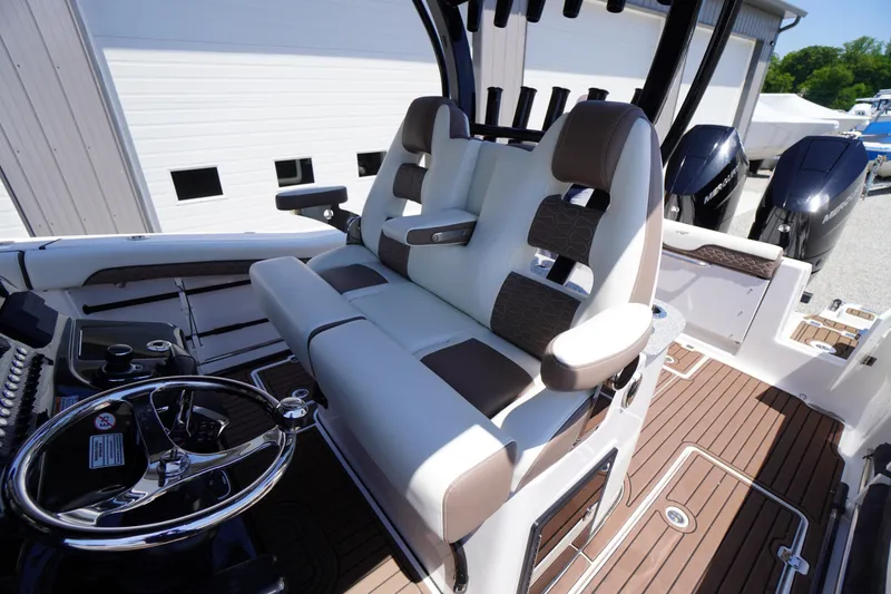 Slide: The Image of 2024 Tidewater 320 CC Adventure boat interior with dual seating and modern controls. - 40
