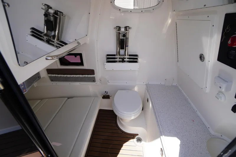 Slide: The Image of 2024 Tidewater 320 CC Adventure boat interior with toilet and seating area. - 43