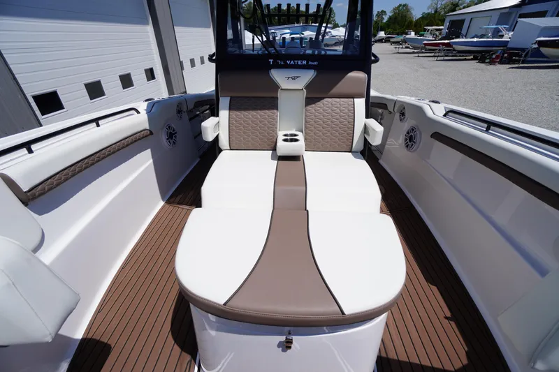 Slide: The Image of 2024 Tidewater 320 CC Adventure boat interior with cushioned seating and cup holders. - 46