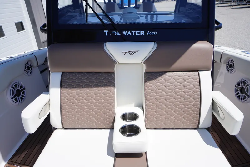 Slide: The Image of 2024 Tidewater 320 CC Adventure boat interior with cushioned seating and cup holders. - 50
