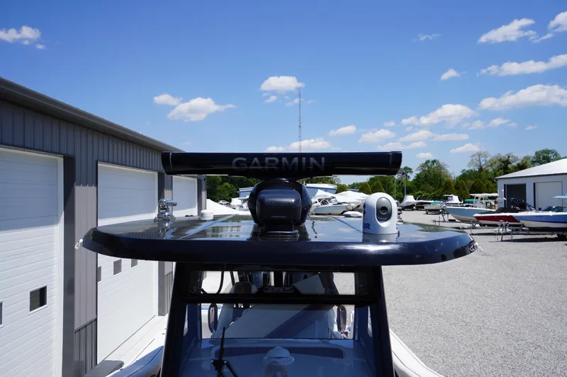 Slide: The Image of 2024 Tidewater 320 CC Adventure boat with Garmin radar, docked under clear blue skies. - 58