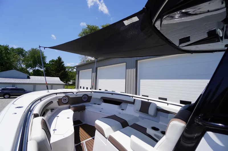 Slide: The Image of 2024 Tidewater 320 CC Adventure boat with shaded seating area and modern design. - 63