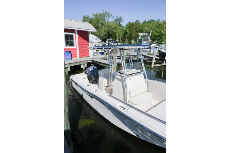 The Image of 2003 Grady-White Fisherman 222 boat docked near a red building, surrounded by greenery. - 0