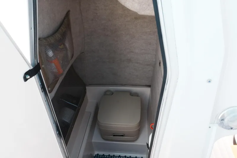 Slide: The Image of 2003 Grady-White Fisherman 222 boat interior with portable toilet and storage net. - 10