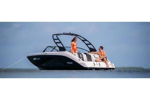 Slide: The Image of 2025 Yamaha AR220 boat on water with two people enjoying the sun. - 8