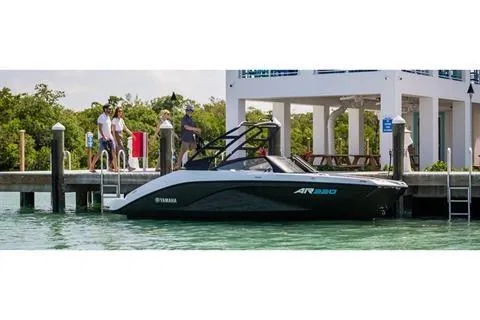 Slide: The Image of 2025 Yamaha AR220 boat docked by a waterfront house. - 9