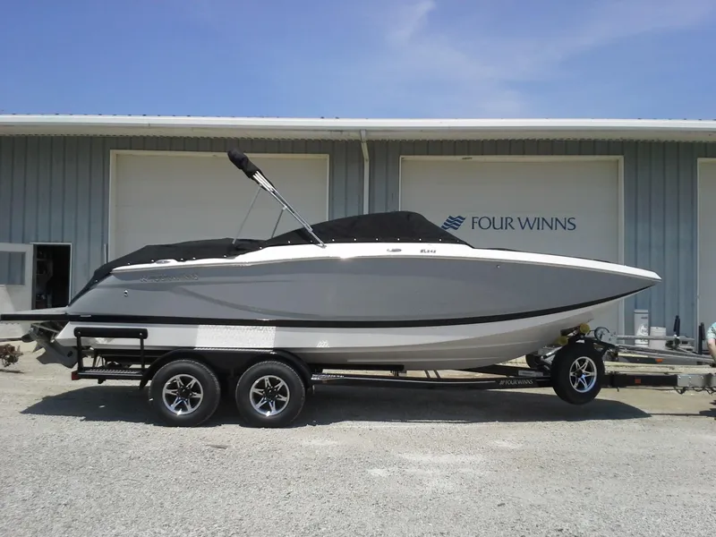 The Image of 2013 Four Winns SL242 boat on trailer in front of warehouse. - 0