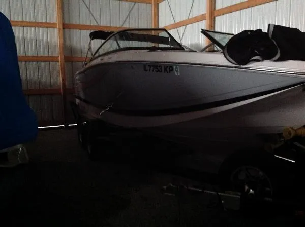 Slide: The Image of 2013 Four Winns SL242 boat stored in a warehouse. - 13