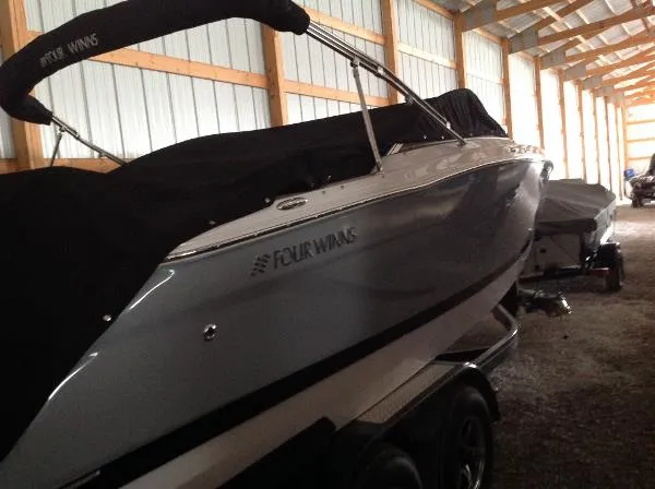 Slide: The Image of 2013 Four Winns SL242 boat in storage facility. - 14