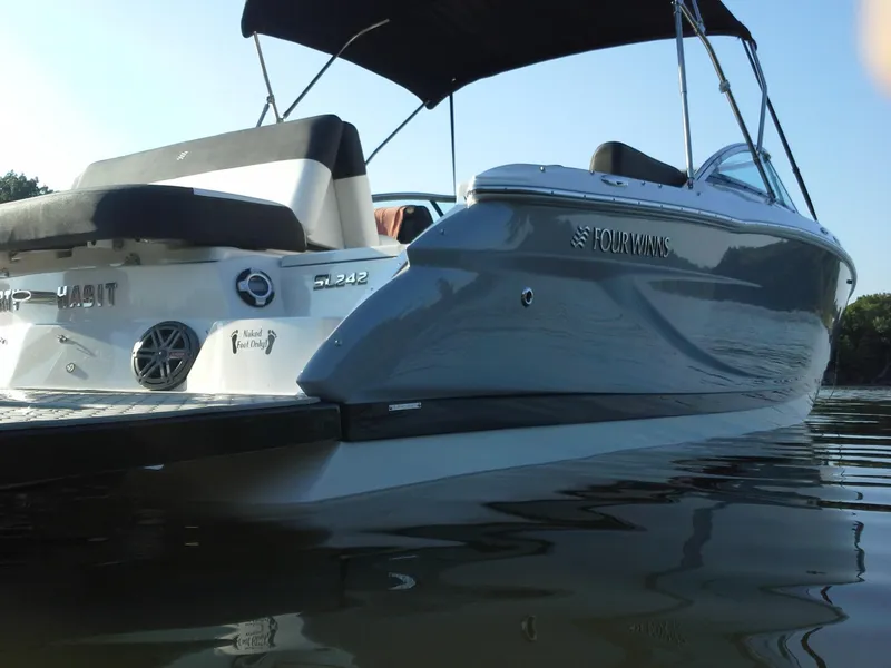 Slide: The Image of 2013 Four Winns SL242 boat on calm water. - 2