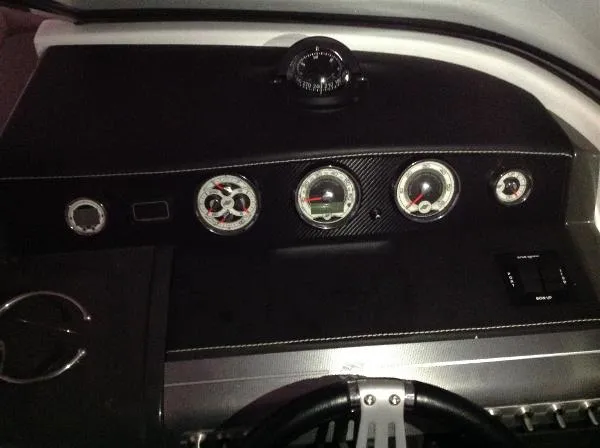 Slide: The Image of Dashboard of a 2013 Four Winns SL242 boat with compass and gauges. - 24