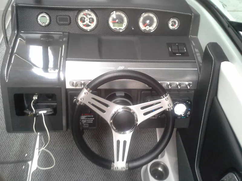 Slide: The Image of Dashboard of a 2013 Four Winns SL242 boat with steering wheel and gauges. - 7