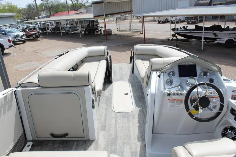 Slide: The Image of 2019 Crest Savannah 250 SLRC pontoon boat interior with plush seating and modern helm. - 11