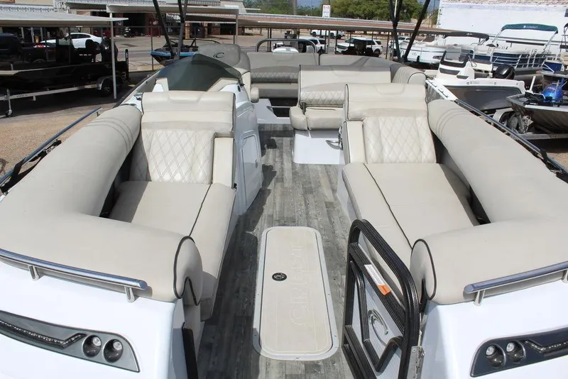 Slide: The Image of 2019 Crest Savannah 250 SLRC pontoon boat with luxurious beige seating and spacious deck. - 16