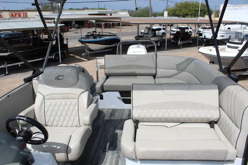 Slide: The Image of 2019 Crest Savannah 250 SLRC pontoon boat with luxurious seating and helm, parked at a marina. - 25