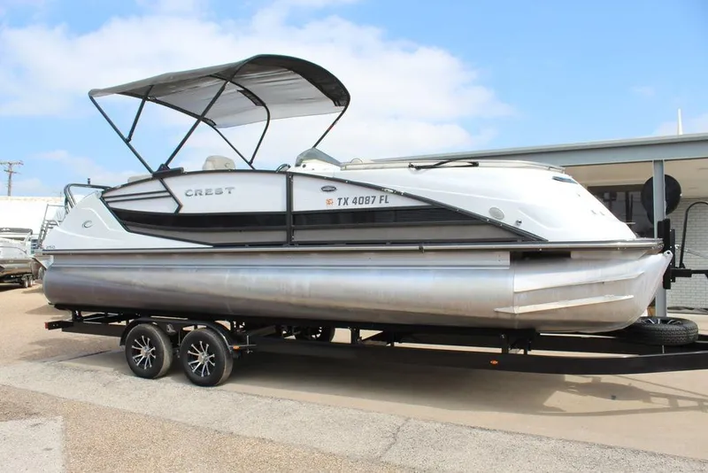 Slide: The Image of 2019 Crest Savannah 250 SLRC pontoon boat on trailer, featuring sleek design and canopy. - 3